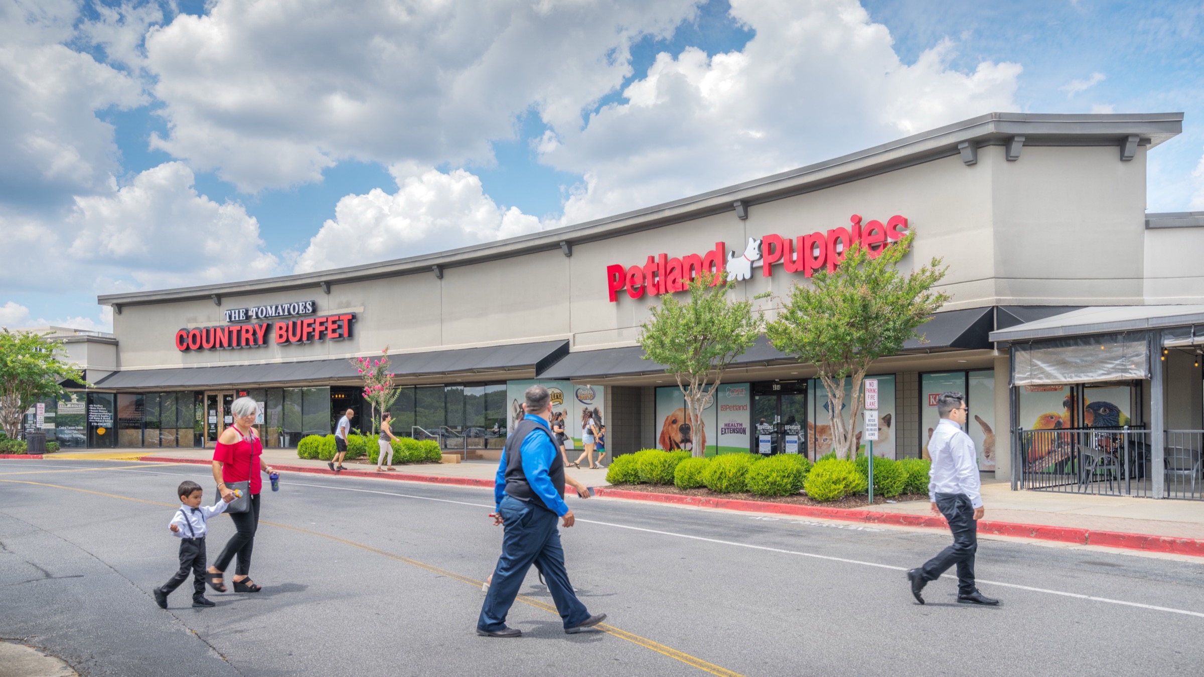 Shoppers walking the storefront sidewalk at Cobb Place Shops